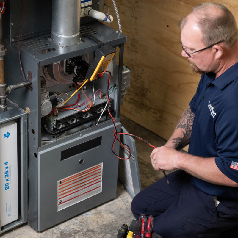 Technician installing a modern energy-efficient furnace in a Grand Rapids home